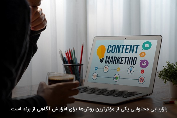 فردی در حال تولید محتوا با لپ‌تاپ برای جذب مخاطبان و افزایش آگاهی از برند